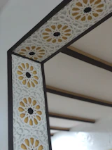 Stylized geometric Arabic pattern in gold on a clean white background.