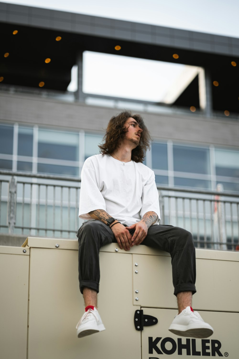 woman in white dress shirt and black pants sitting on white box