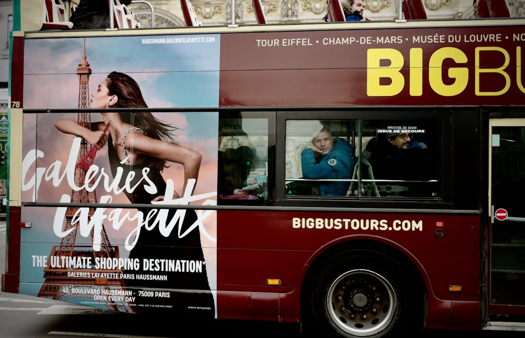 woman in white and black dress standing beside red bus