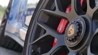 Close-up of a Porsche GT3RS wheel with 4s racing 9rs rim in a dark garage setting.