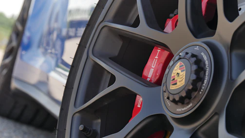 Close-up of a Porsche GT3RS wheel with 4s racing 9rs rim in a dark garage setting.