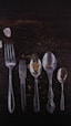 stainless steel spoons and fork on brown wooden table