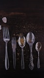 stainless steel spoons and fork on brown wooden table
