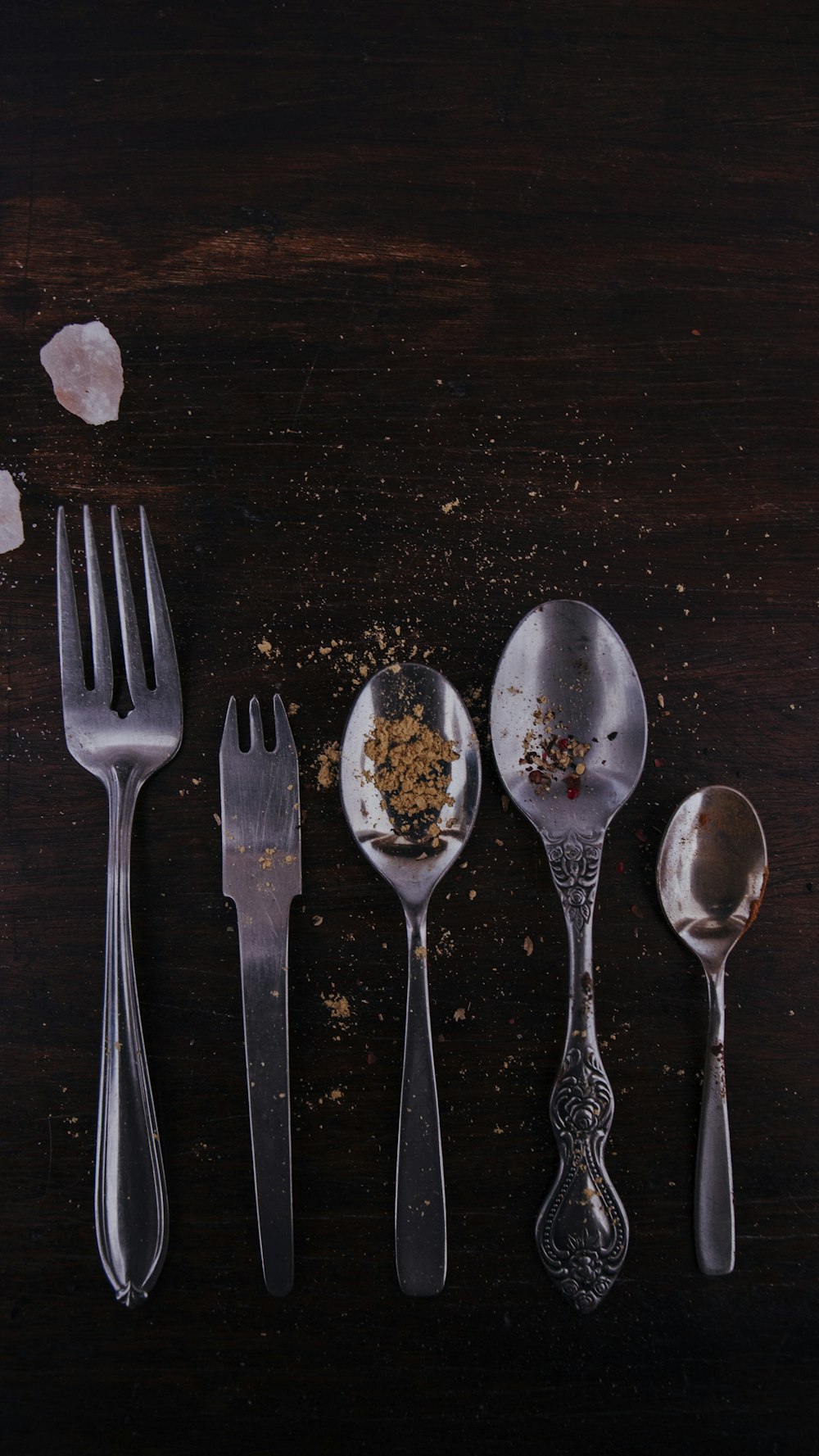 茶色の木製のテーブルにステンレス製のスプーンとフォーク