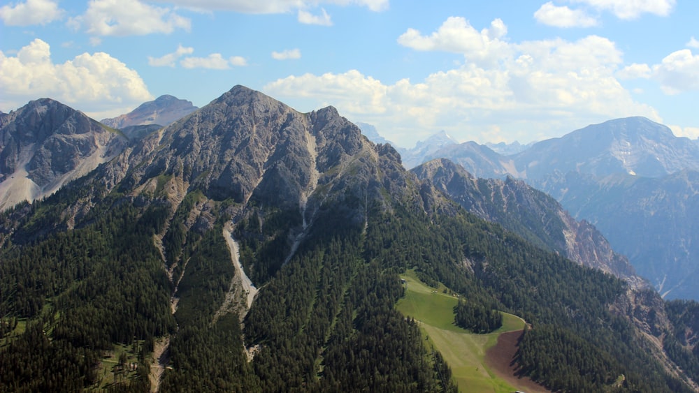 green trees on mountain under blue sky during daytime