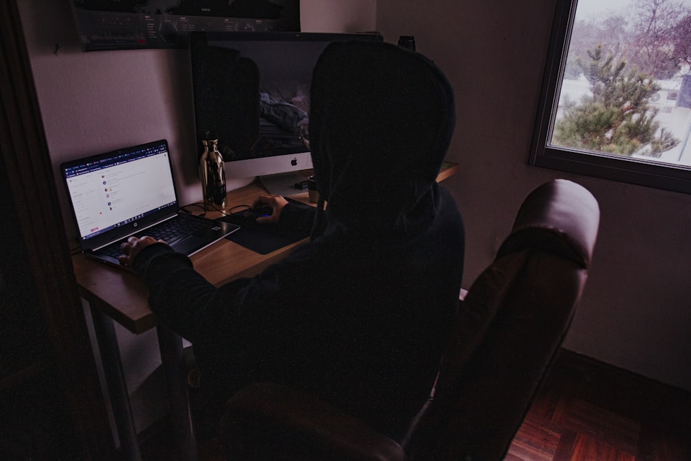 person sitting on chair in front of computer