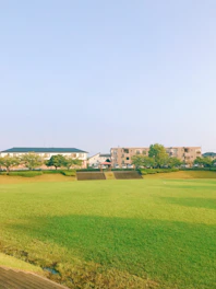 A serene residential plot with clear boundaries and lush greenery under a bright sky.