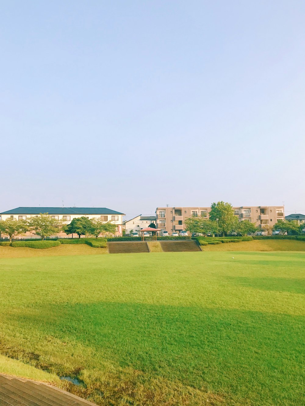 green grass field near houses during daytime