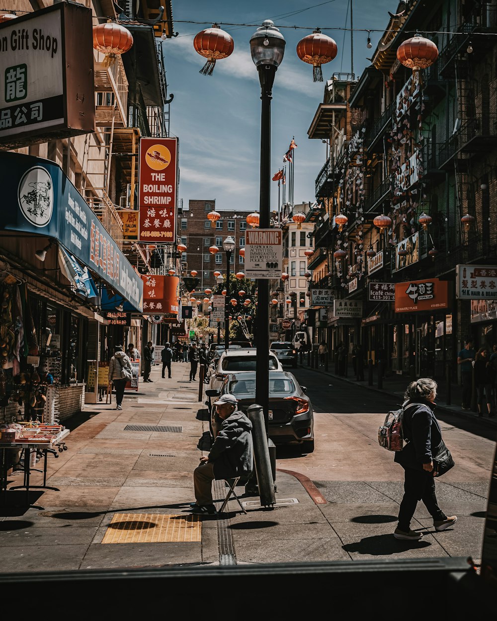 man in black jacket walking on sidewalk during daytime