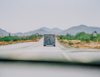 A Doroob Logistics truck on a highway surrounded by desert landscape under a clear sky.