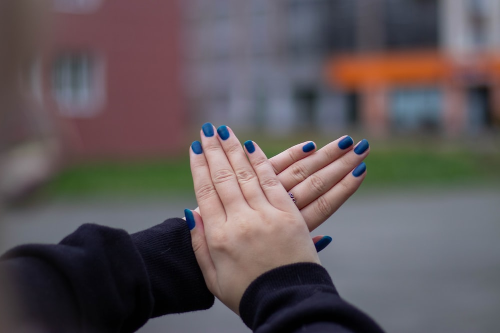 person with blue manicure and blue manicure