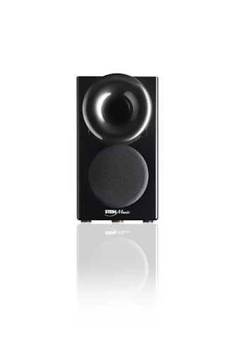 A sleek black speaker with a glossy, rounded top section and a fabric-covered lower section displaying the Stein Music logo. The speaker is reflected on the white surface it stands upon, adding a sense of elegance and modernity.