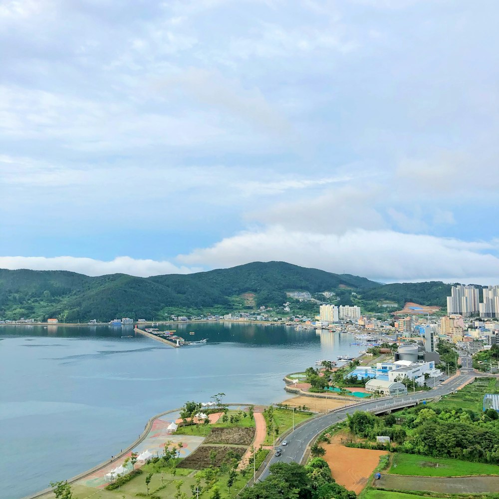 city buildings near body of water under white clouds during daytime