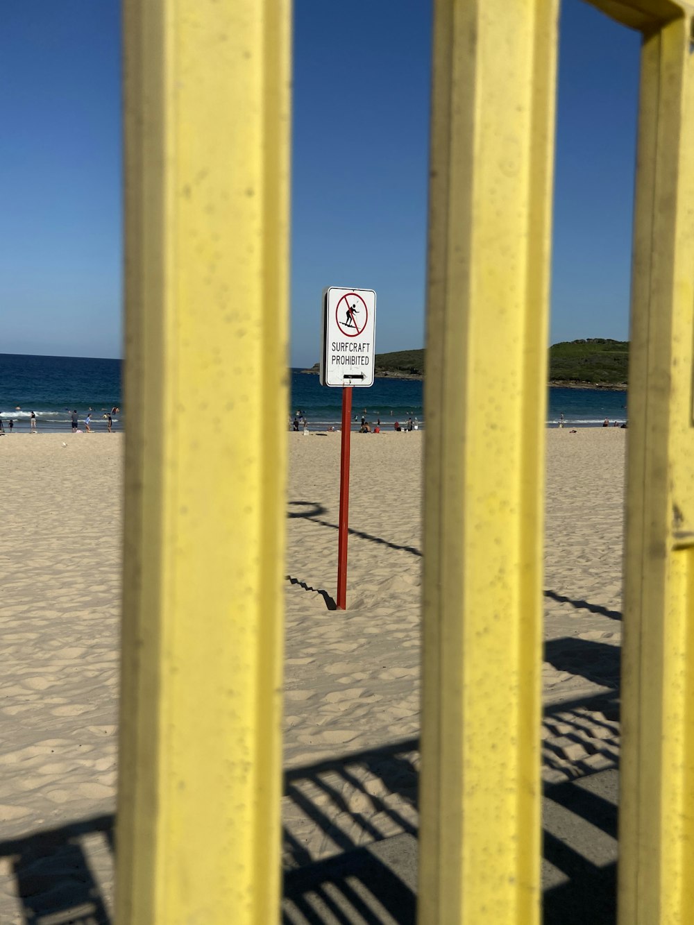 yellow wooden fence on beach during daytime