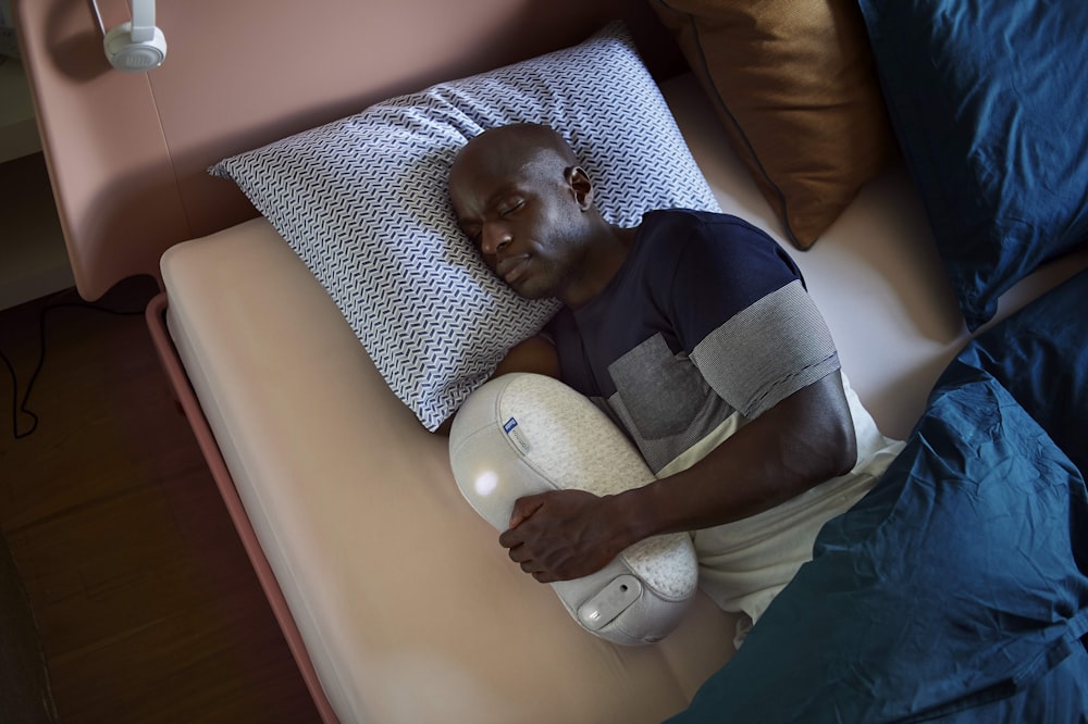 hombre con camiseta negra acostado en la cama