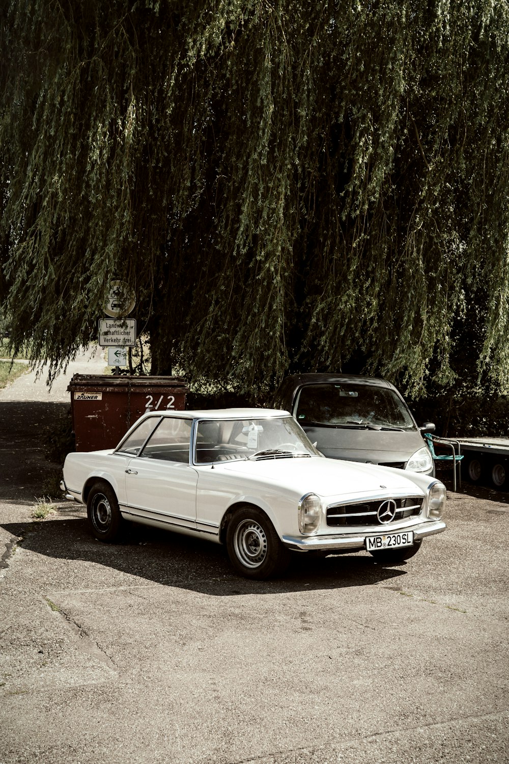 white mercedes benz coupe parked on road side during daytime