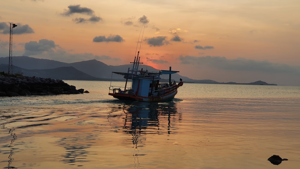 Braunes Boot auf See bei Sonnenuntergang