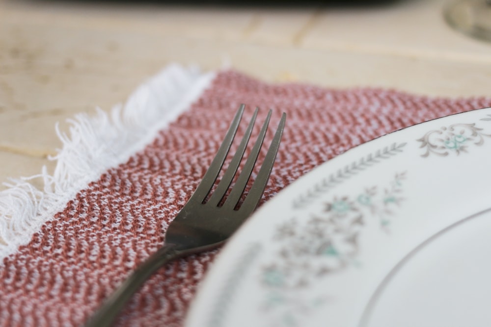 stainless steel fork on white and blue floral ceramic plate