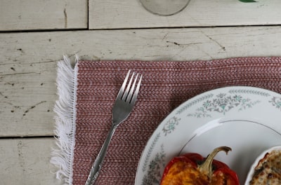 stainless steel fork on white and blue floral round plate leftovers zoom background