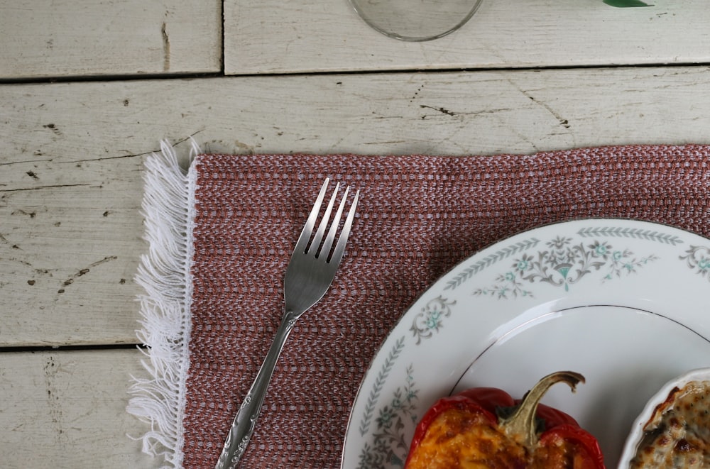 stainless steel fork on white and blue floral round plate