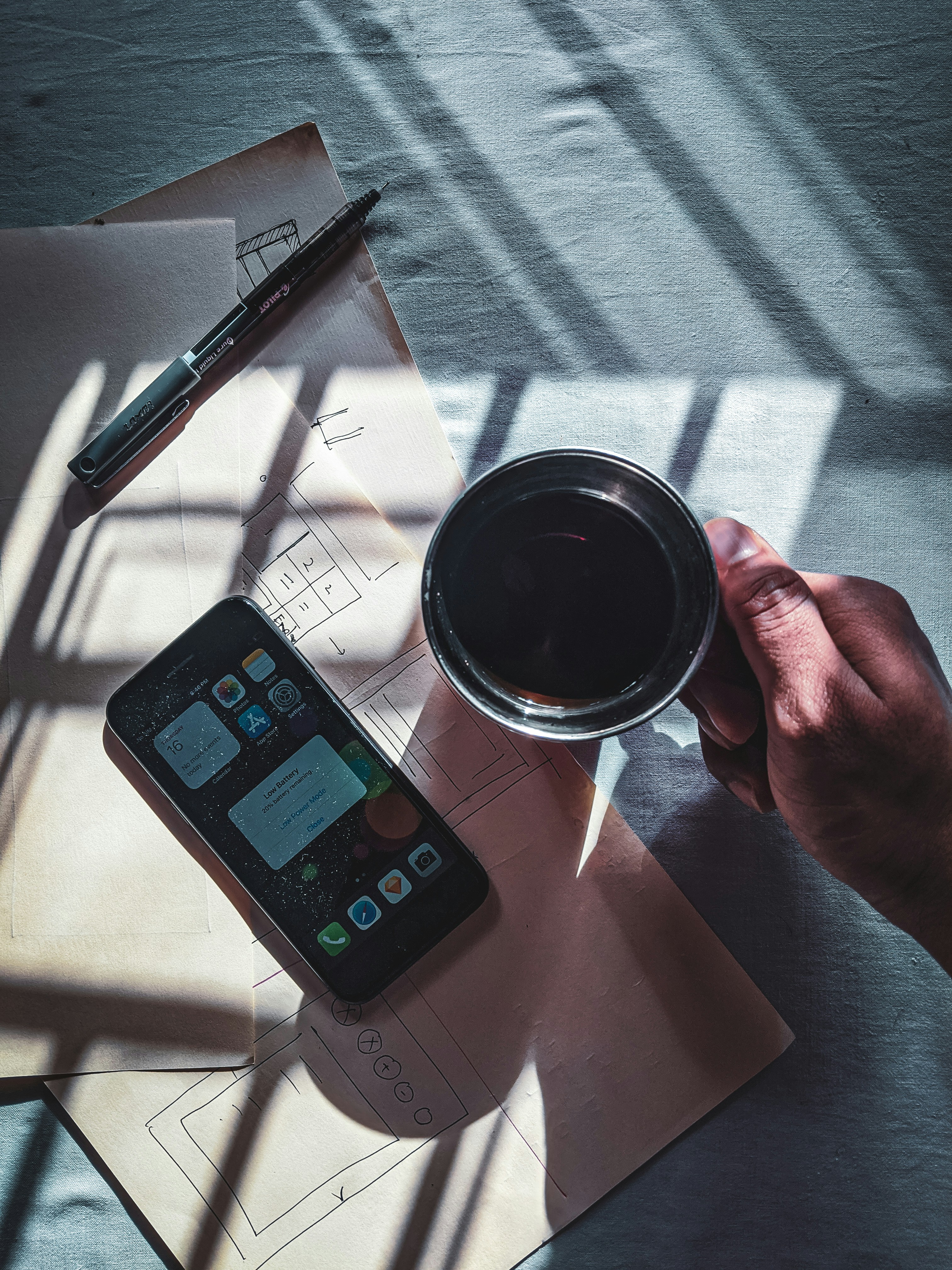 black iphone 4 beside black pen
