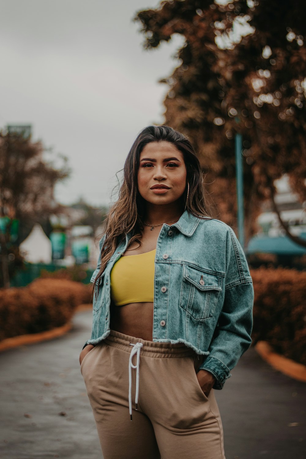 woman in blue denim jacket standing on road during daytime