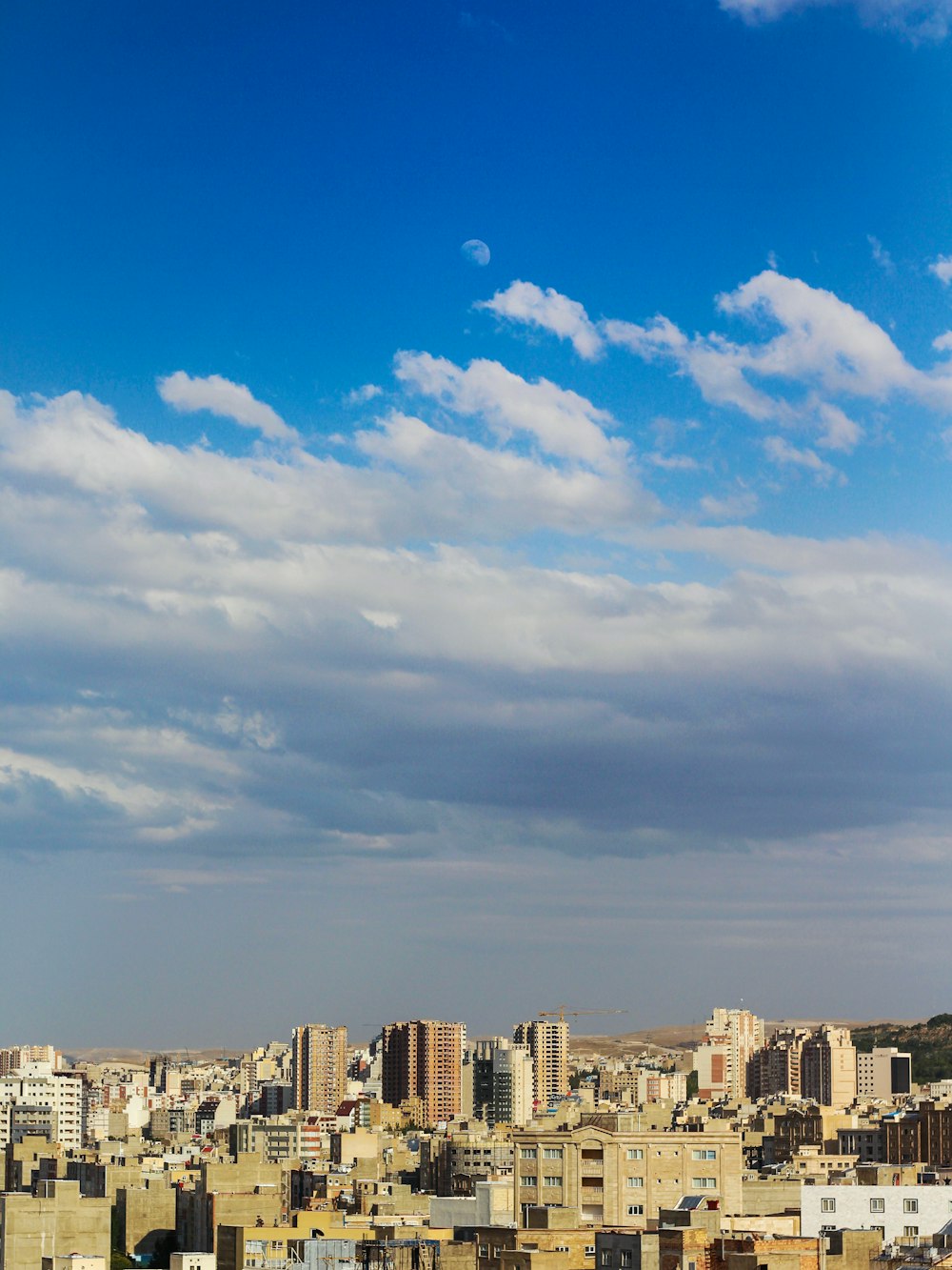 city buildings under blue sky and white clouds during daytime