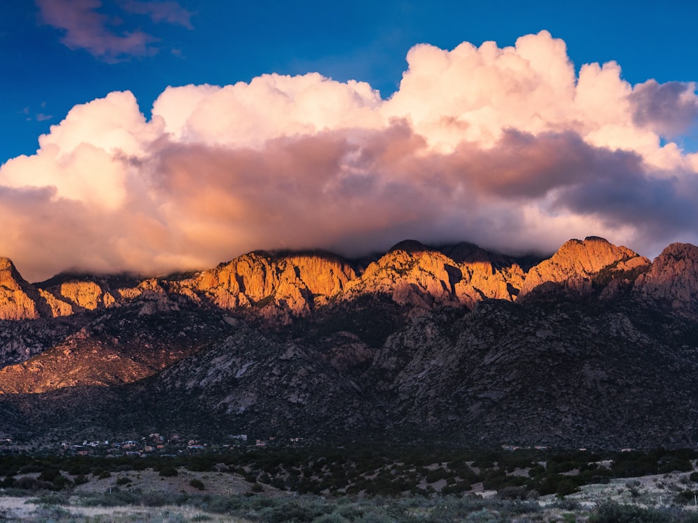 brown and black mountain under white clouds