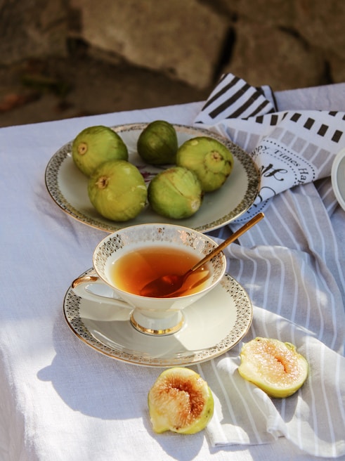 A steaming cup of tea with a soft glow, resting beside a plate of golden fries