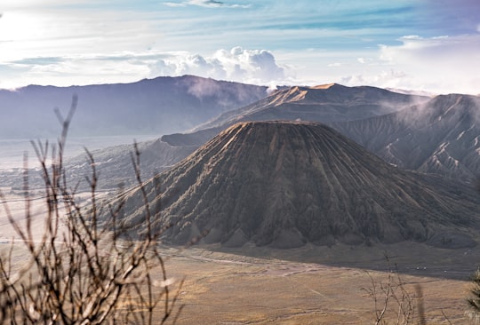 brown and black mountain under white clouds during daytime in Bromo Tengger Semeru National Park Indonesia