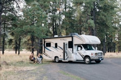 people standing near white rv trailer during daytime
