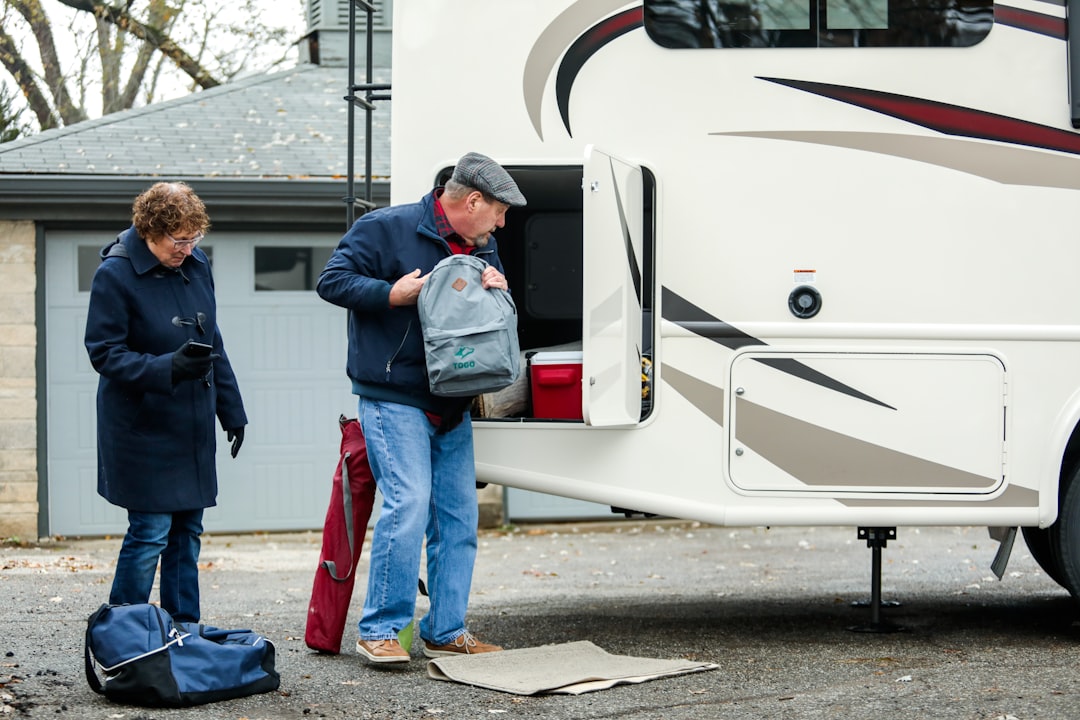 man in blue denim jeans standing beside white car, Download the free Togo RV app today to unleash your clever RV camping