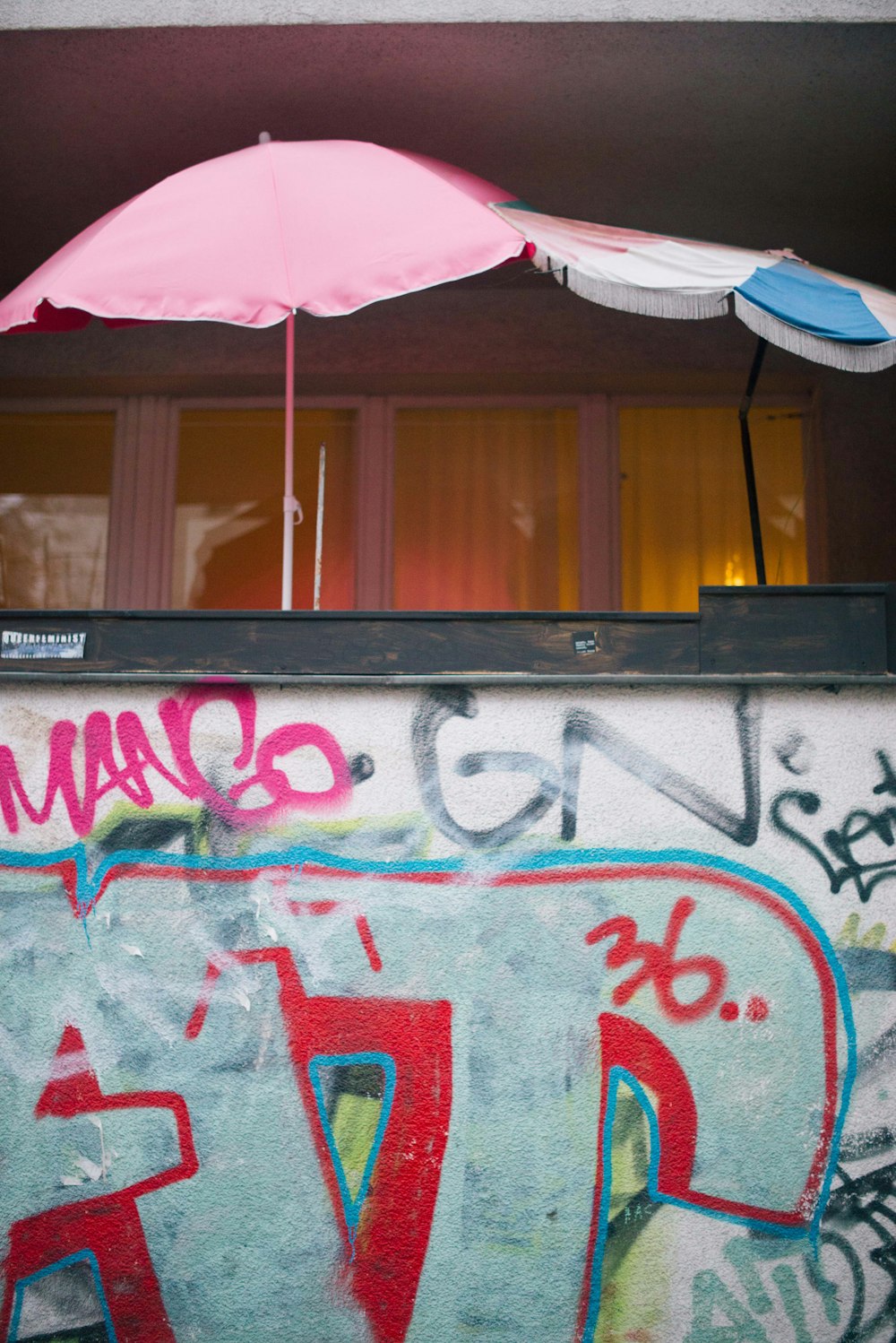 회색 콘크리트 벽에 분홍색 우산