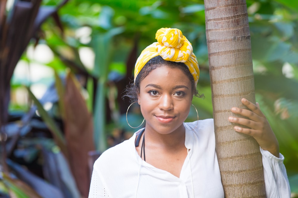 woman in white shirt wearing yellow and white floral headband