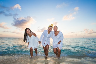 man in white button up shirt beside woman in white shirt on beach during daytime