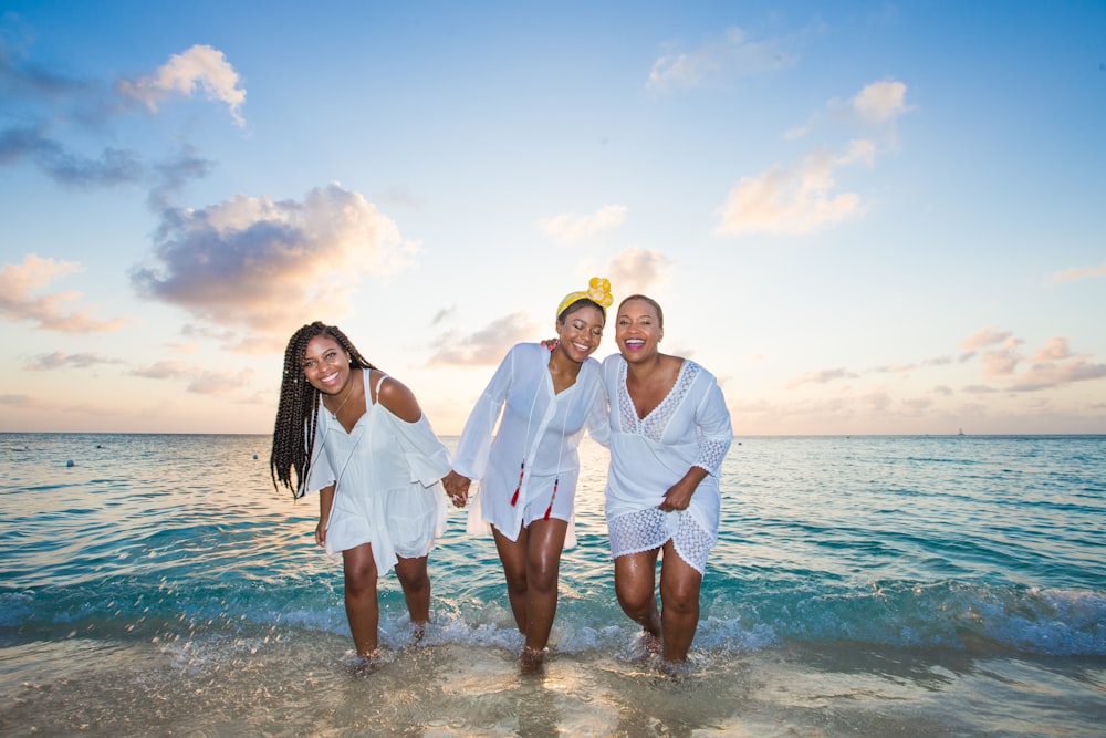 man in white button up shirt beside woman in white shirt on beach during daytime