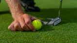 person holding yellow golf ball