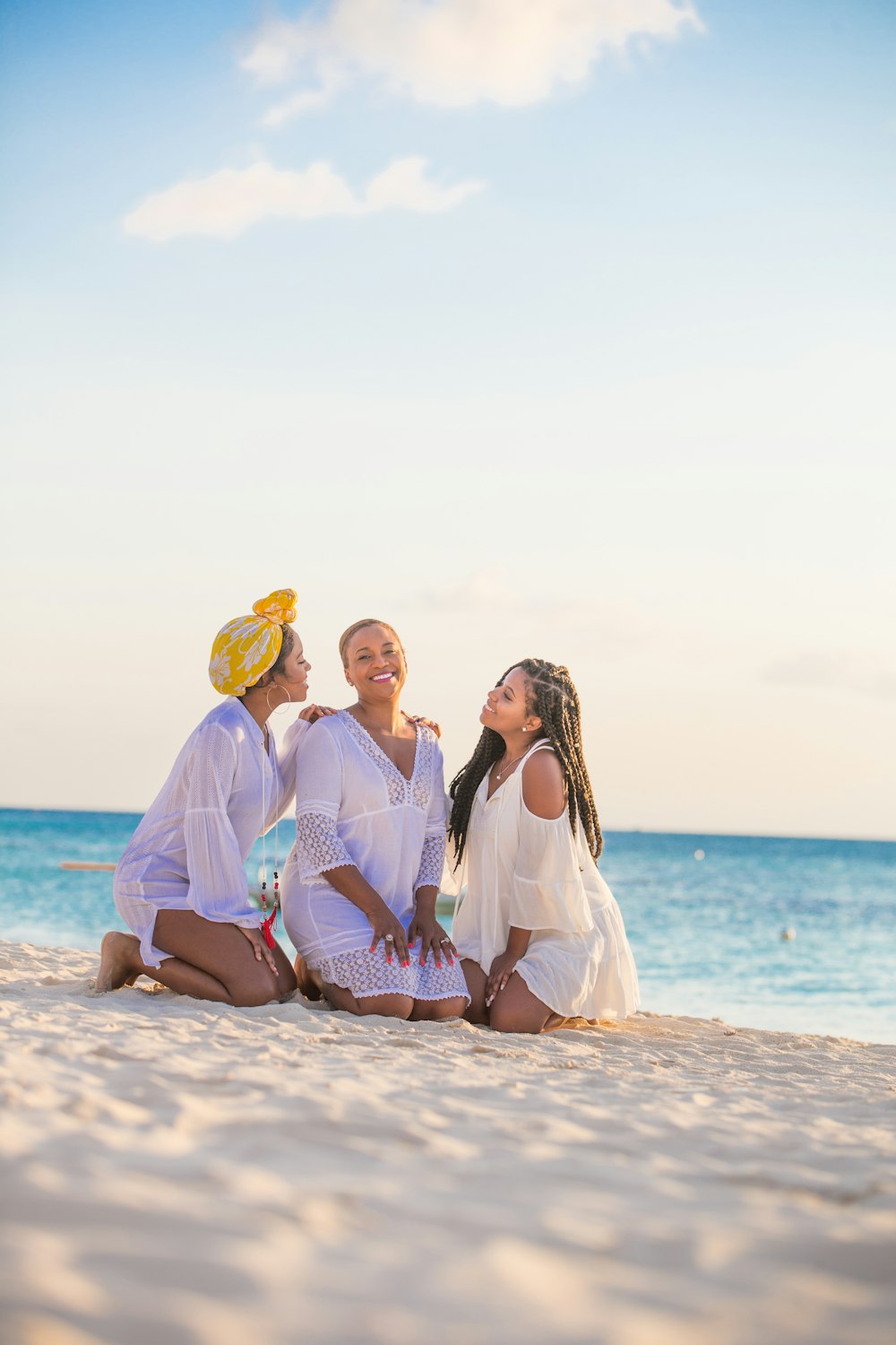 woman in white dress sitting on beach during daytime