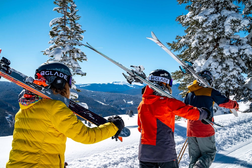 赤いジャケットと黒いズボンを身にまとい、白いヘルメットをかぶった男が雪の上をスキーのブレードに乗っている