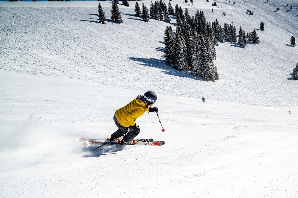 낮 동안 눈 덮인 땅에서 빨간 스키 보드를 타는 녹색 재킷을 입은 사람