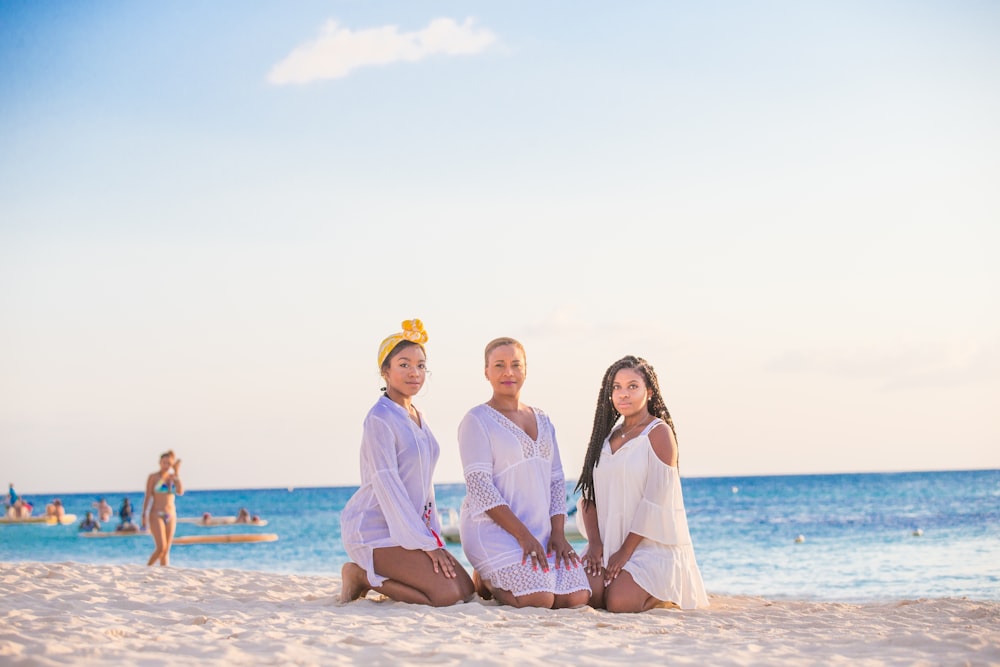 man in white dress shirt standing beside woman in white dress on beach during daytime