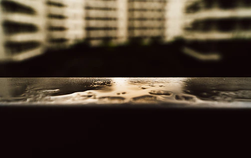 Close-up of a reflective wet surface after pressure washing, highlighting the dark and glossy finish.