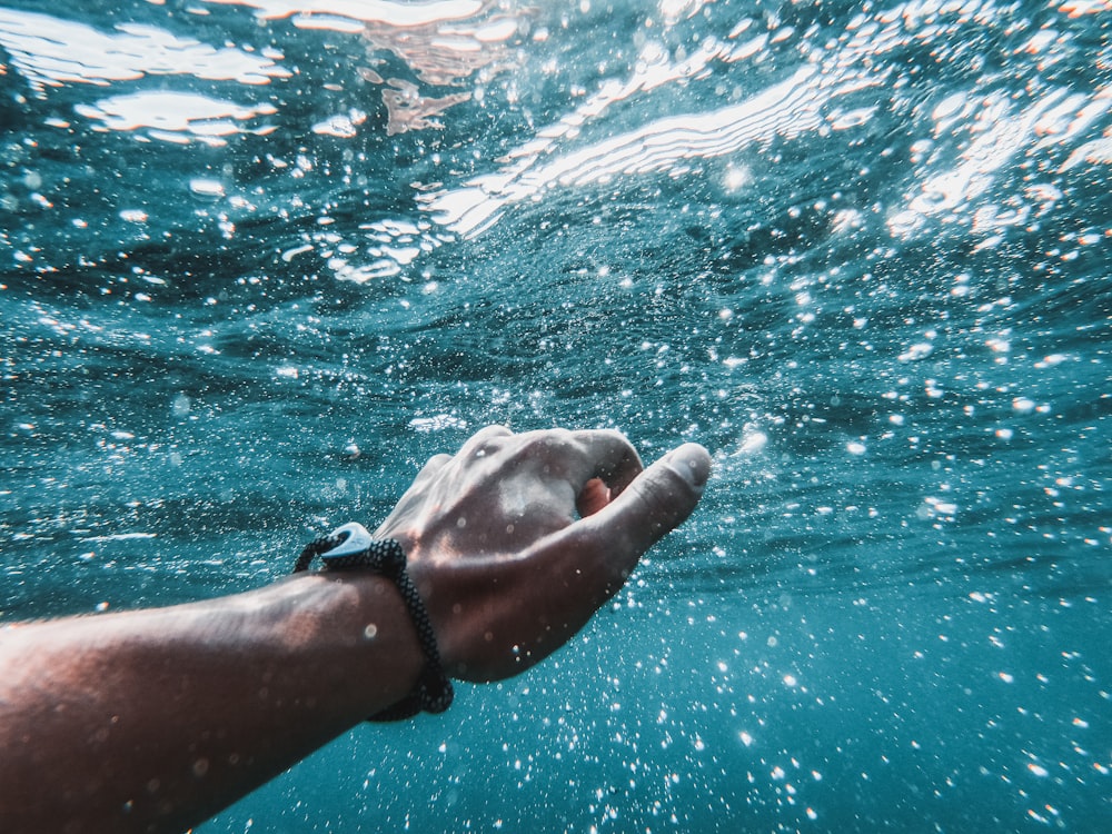 person in black bracelet in water