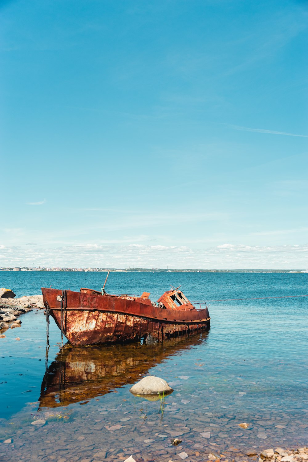 brown boat on sea under blue sky during daytime