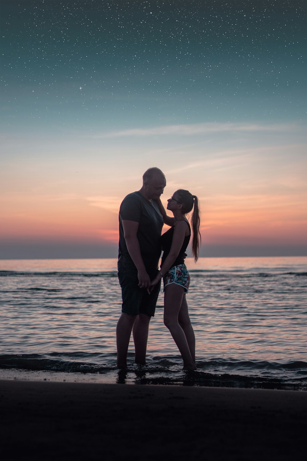 Coppia che cammina sulla spiaggia durante il tramonto