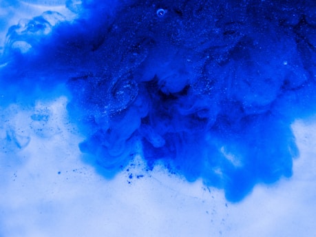 A close-up of a textured ink splash blending into a sharp pixel grid with an electric cobalt blue accent line.