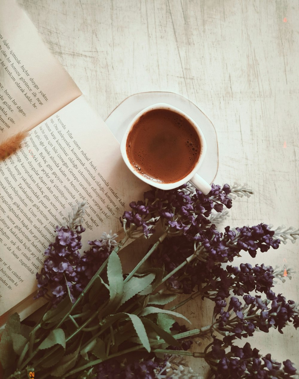 purple flowers beside white ceramic mug