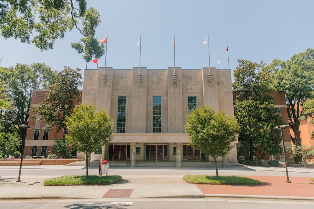 brown concrete building with flags on top during daytime