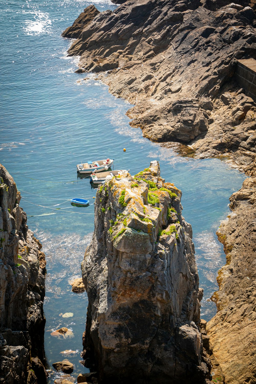 white and brown wooden house on cliff near body of water during daytime