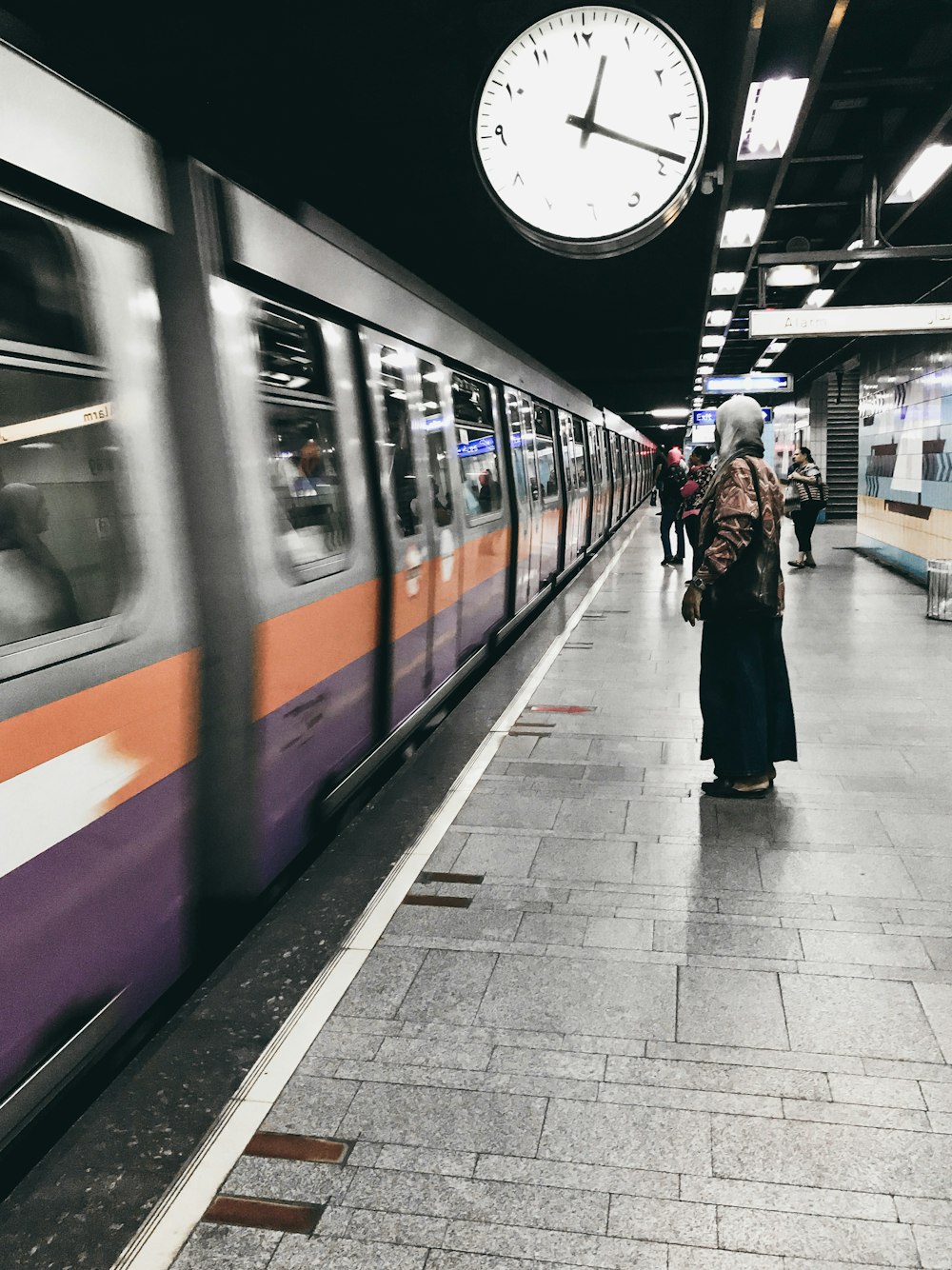 people walking on sidewalk near train